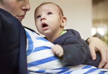 Baby in den Armen der Mutter mit Blick nach oben - MFF003147