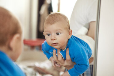 Baby wird gehalten, um sein eigenes Spiegelbild zu sehen - MFF003155