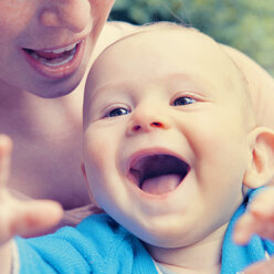 Glückliches Baby in den Armen der Mutter - MFF003159