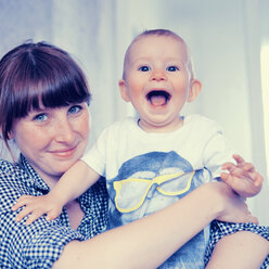 Happy mother holding her baby son - MFF003161