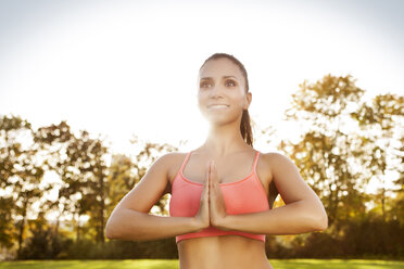 Lächelnde Frau beim Yoga im Freien - MFF003166