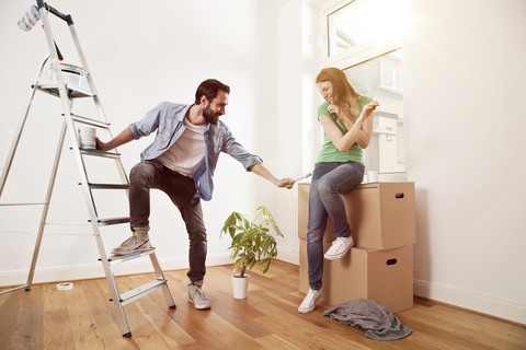 Verspieltes junges Paar bei der Renovierung einer Wohnung, lizenzfreies Stockfoto