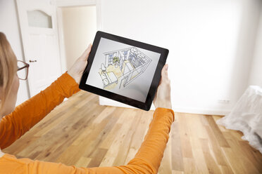 Woman holding interior design sketch in empty apartment - MFF003284