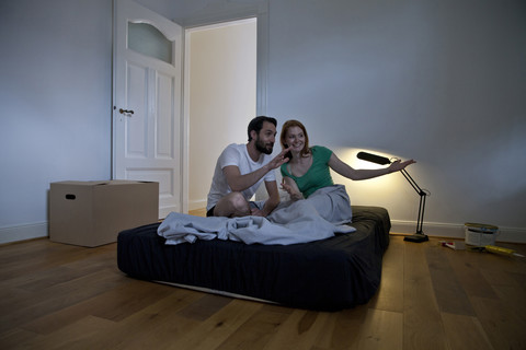 Young couple spending the first night in their new apartment making plans stock photo
