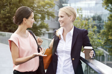 Zwei Geschäftsfrauen unterhalten sich während einer Kaffeepause im Freien - MFF003341
