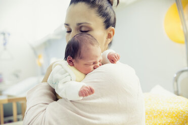 Mutter hält ihr neugeborenes Baby im Krankenhausbett - MFF003362