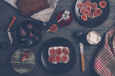 Toasted rye bread with cream cheese, sliced figs and olive oil on dark wood - RTBF000337