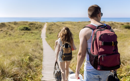 Back view of friends on the way to the beach - MGOF002362