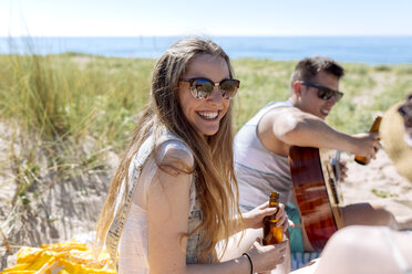 Porträt eines glücklichen Teenagers, der mit seinen Freunden am Strand Spaß hat - MGOF002364