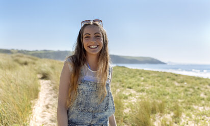 Portrait of happy teenage girl on the beach - MGOF002368