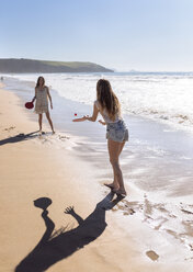 Two women playing beach paddles on the beach - MGOF002381