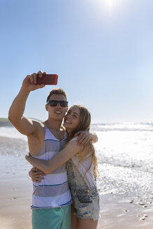 Junges verliebtes Paar macht Selfies am Strand - MGOF002396