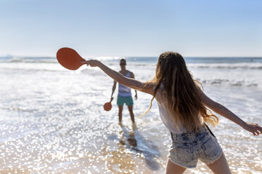 Rückansicht eines Teenagers, der am Strand mit Paddeln spielt - MGOF002398