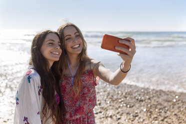 Two best friends taking selfie with smartphone on the beach - MGOF002402