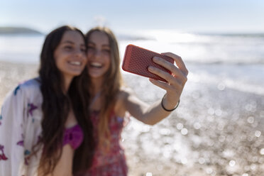 Two best friends taking selfie with smartphone on the beach - MGOF002403