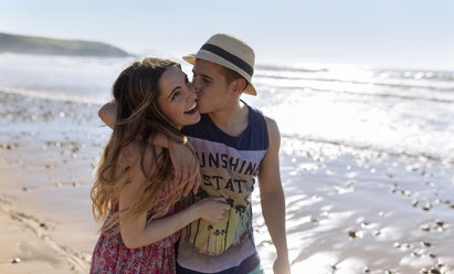 Happy young couple in love walking along the beach - MGOF002410