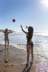 Zwei Freunde spielen mit Ball am Strand - MGOF002412