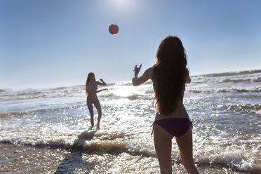 Zwei Freunde spielen mit Ball am Strand - MGOF002413