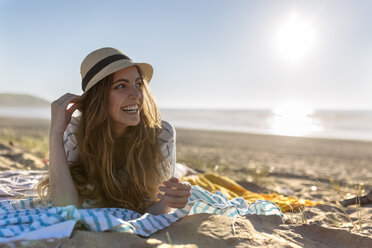 Glückliches Teenager-Mädchen am Strand liegend - MGOF002425