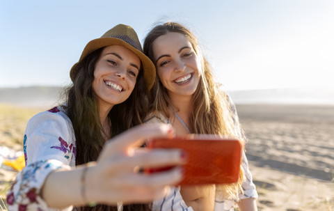 Zwei beste Freunde machen ein Selfie mit Smartphone am Strand, lizenzfreies Stockfoto