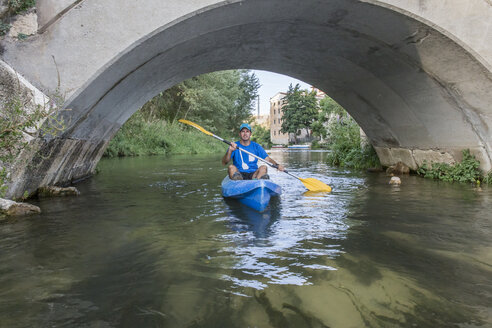 Spanien, Segovia, Mann in einem Kanu unter einer Brücke - ABZF001186