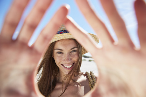 Porträt einer lächelnden jungen Frau am Strand, lizenzfreies Stockfoto