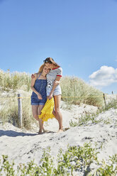 Zwei glückliche Freundinnen spazieren in den Dünen am Strand - SRYF000026
