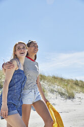 Two happy female friends walking on the beach - SRYF000028