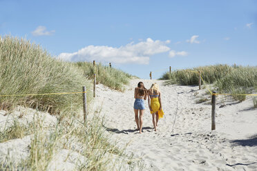 Zwei Freundinnen gehen durch die Dünen und verlassen den Strand - SRYF000039