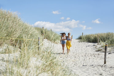 Zwei Freundinnen gehen durch die Dünen zum Strand - SRYF000040