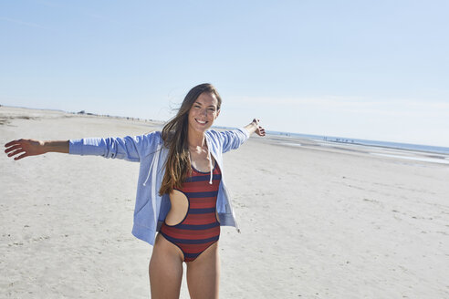 Happy young woman with outstretched arms on the beach - SRYF000086