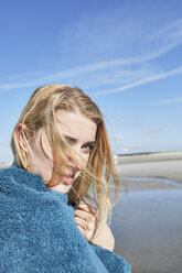 Junge Frau in ein Handtuch gewickelt am Strand - SRYF000103