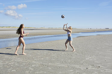 Zwei junge Frauen am Strand spielen Beachvolleyball - SRYF000106