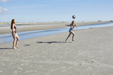 Zwei junge Frauen am Strand spielen Beachvolleyball - SRYF000107