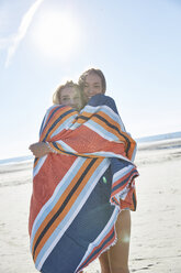 Zwei junge Frauen in einer Decke eingewickelt am Strand - SRYF000133