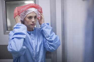 Frau zieht sterile Schutzkleidung an - ZEF010117