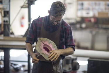 Sculptor holding mould in studio - ZEF010150