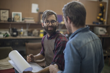 Two men in artist studio planning together - ZEF010156