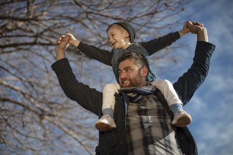 Vater trägt seinen Sohn auf den Schultern, lizenzfreies Stockfoto