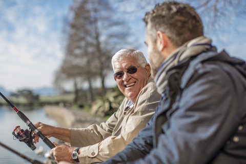 Älterer Mann und erwachsener Sohn fischen zusammen, lizenzfreies Stockfoto