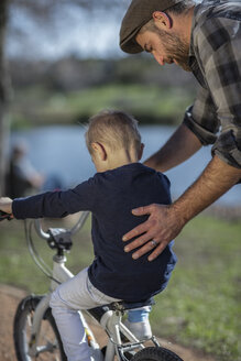 Father supporting son on bike - ZEF010211