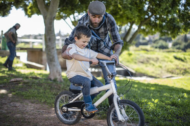 Vater unterstützt Sohn auf dem Fahrrad - ZEF010212