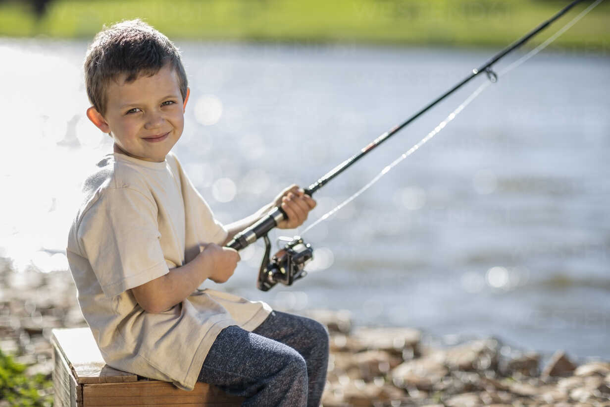 Little boy fishing in lake stock photo
