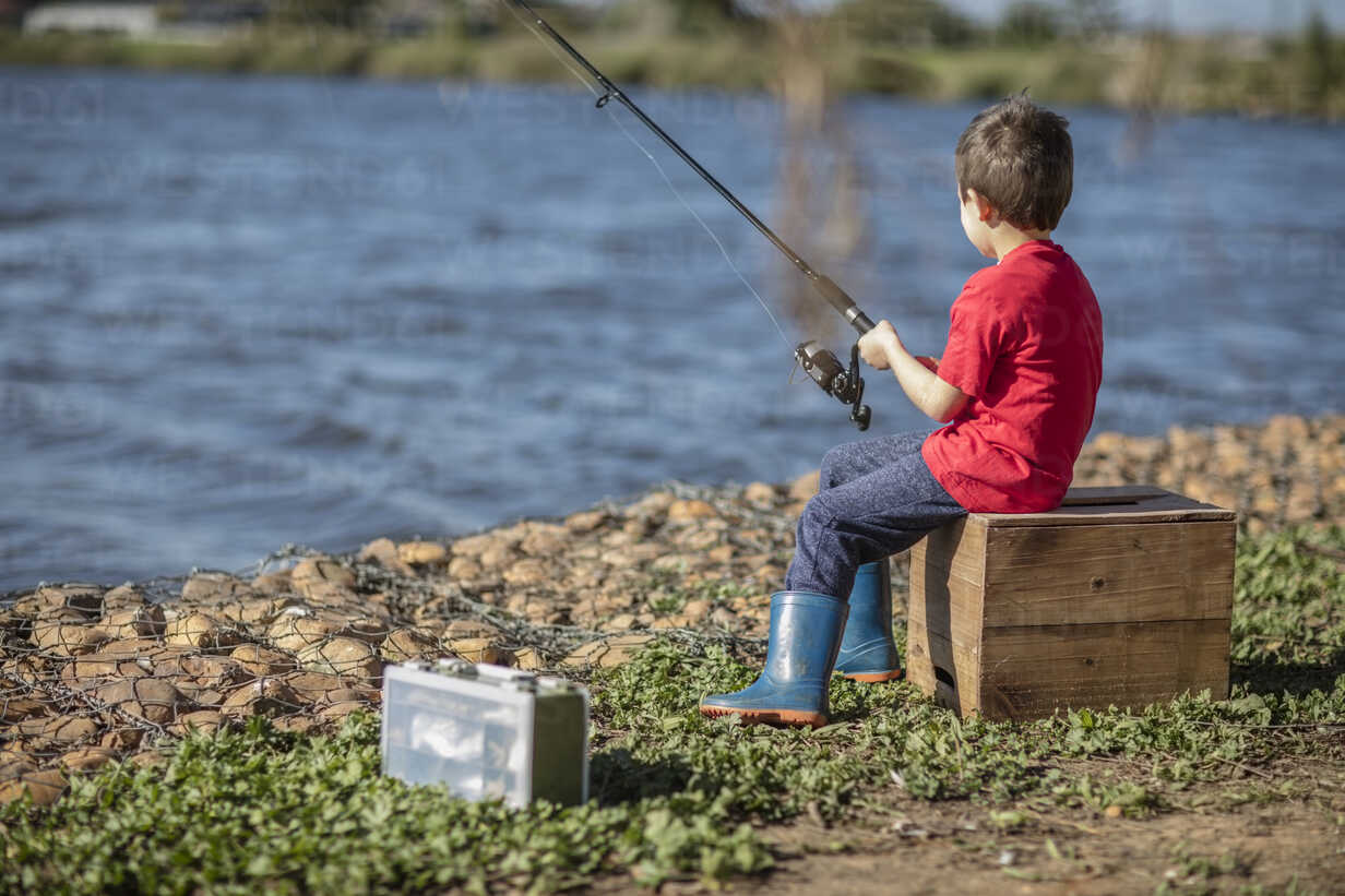 Little boy fishing in lake stock photo
