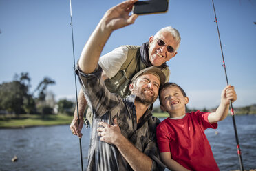 Grandfather, father and son taking a selfie with fishing rods - ZEF010229