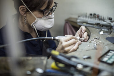 Goldschmied bei der Arbeit an Schmuckstücken in der Werkstatt - ZEF010238