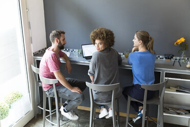 Three young people in a cafe using laptop - WESTF021708