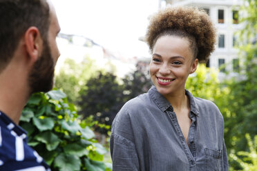 Young woman smiling at man in park - WESTF021724