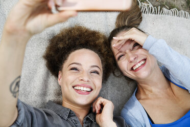 Two happy young women taking a selfie on blanket - WESTF021747