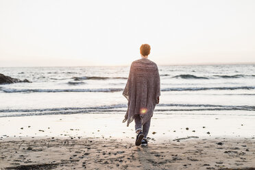 France, Crozon peninsula, woman walking on the beach at sunset - UUF008345